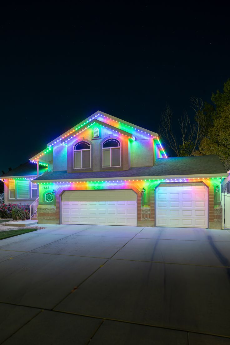 Home with multicolor permanent LED roofline lighting at night