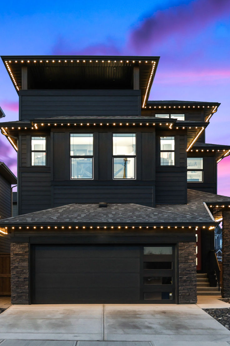 Modern home outlined in warm white permanent LED roofline lighting at sunset