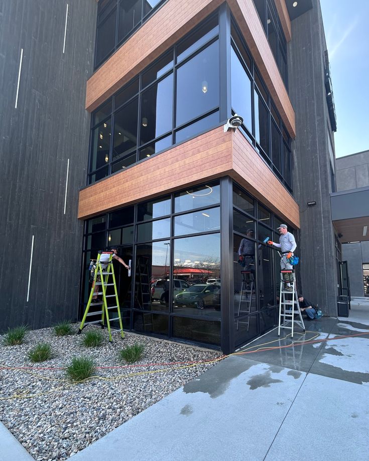 Digii crew cleaning tall exterior windows with squeegees and deionized water